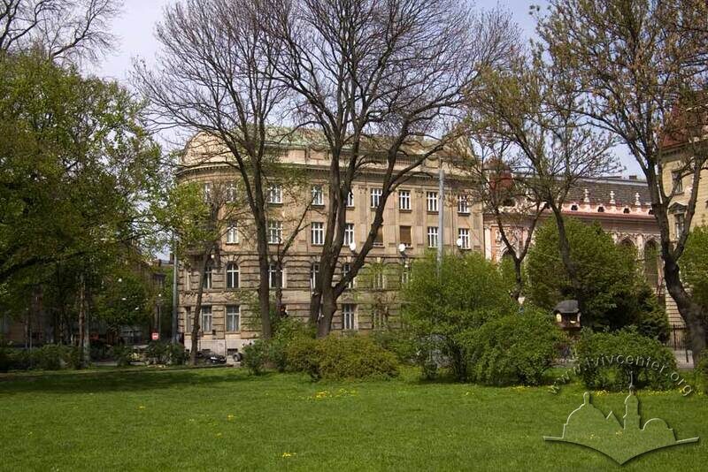 Вул. Листопадового чину, 8. Вид на південно-східний фасад будинку крізь дерева скраю парку ім. І. Франка
